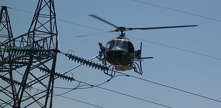 Helicóptero junto a linhas elétricas